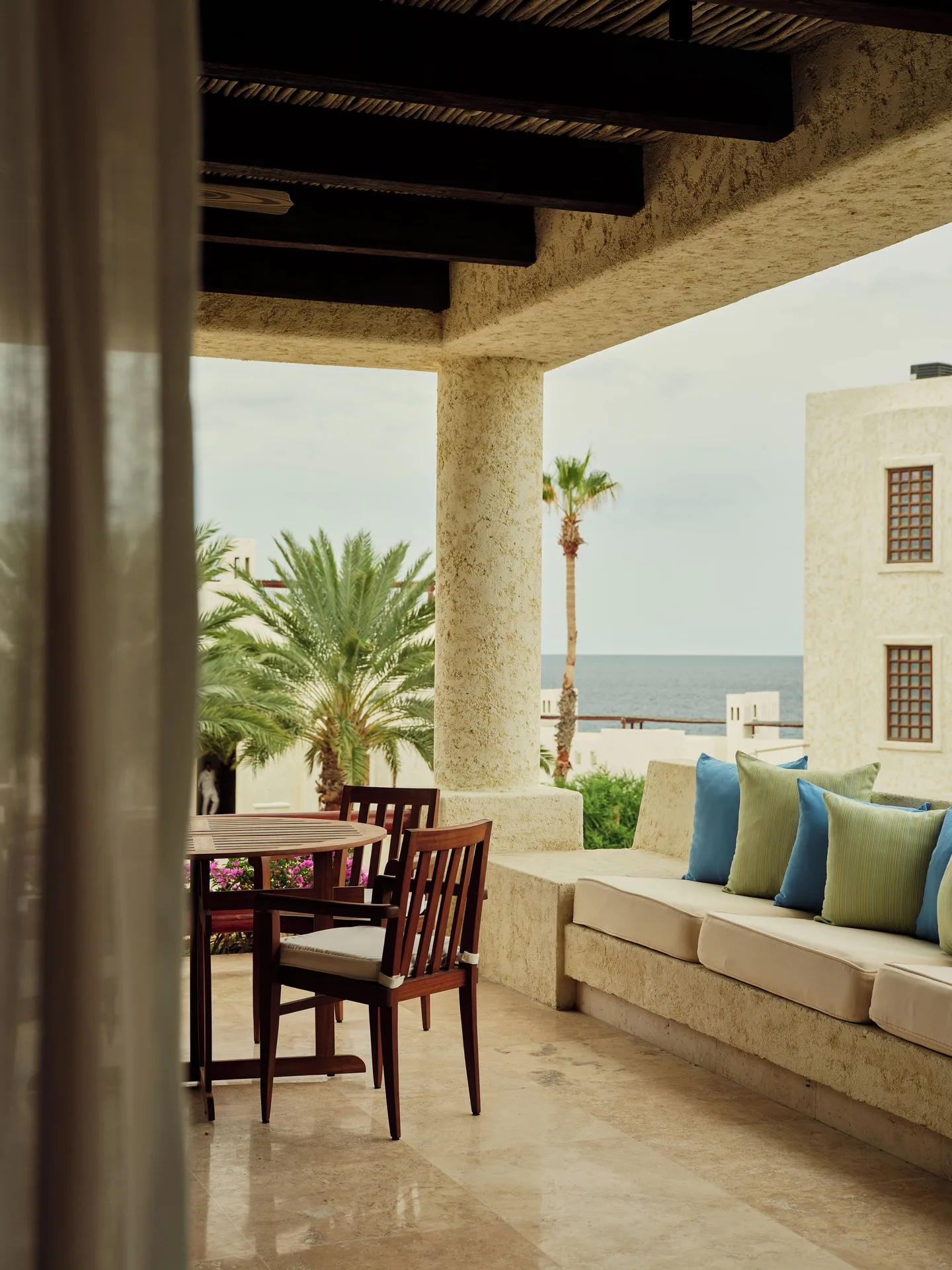 Two Bedroom Gardenview Suite terrace with seating and ocean glimpse at Las Ventanas al Paraiso.