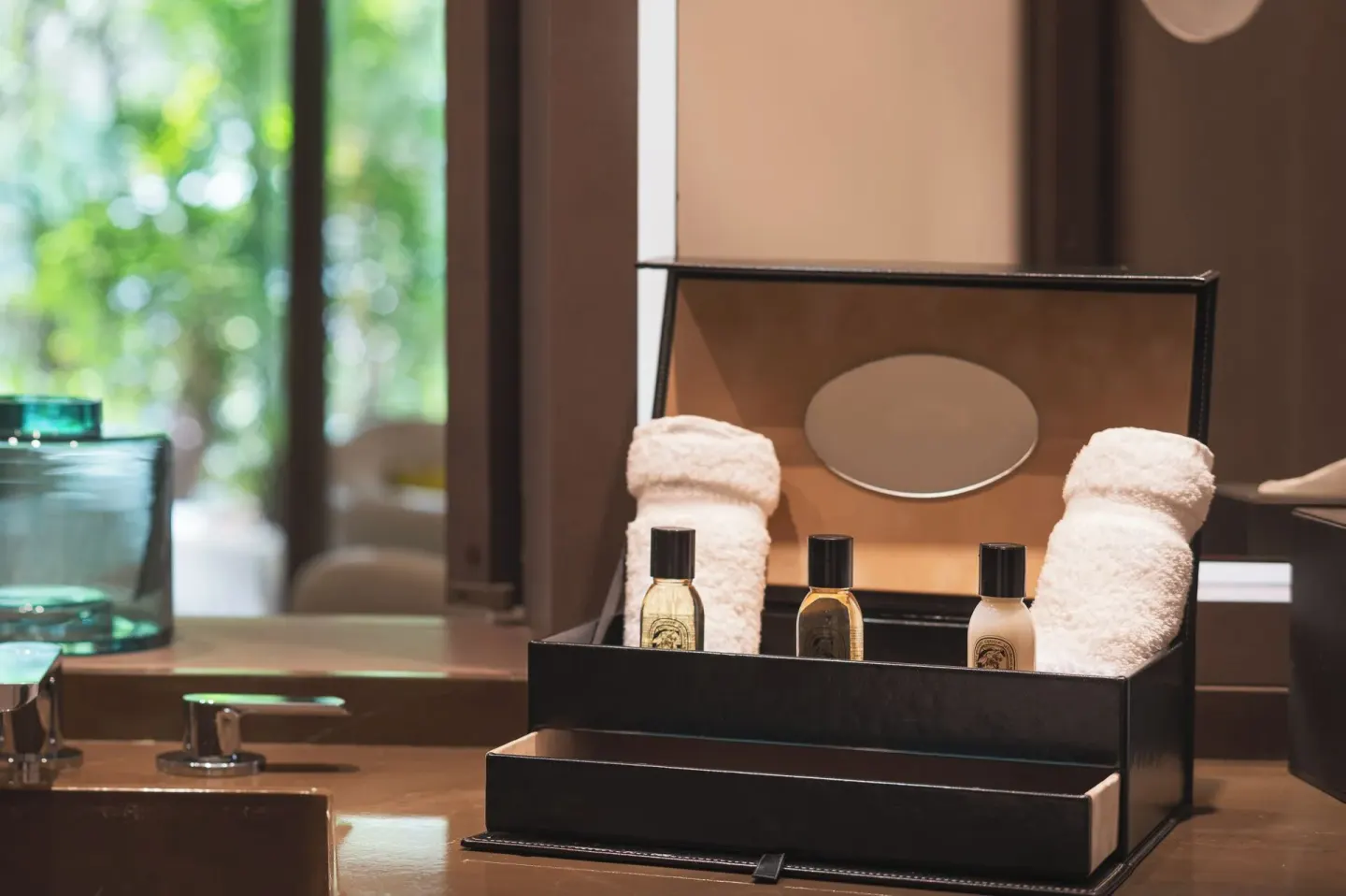 Bath amenities and rolled towels on a vanity at Le Barthélemy Hotel & Spa.