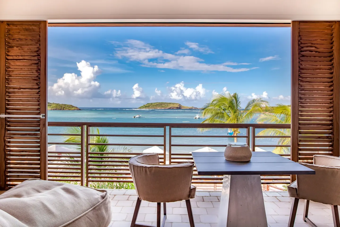 Covered balcony with bay view and seating at Le Barthélemy Hotel & Spa.