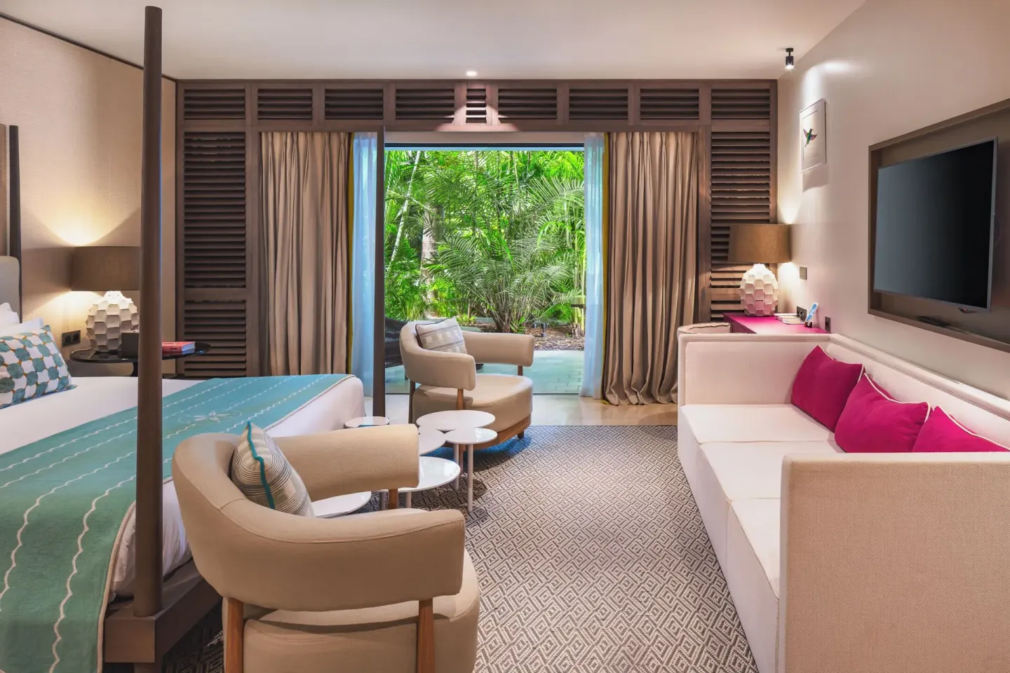 Guest room with king bed, sofa, and garden outlook at Le Barthélemy Hotel & Spa.