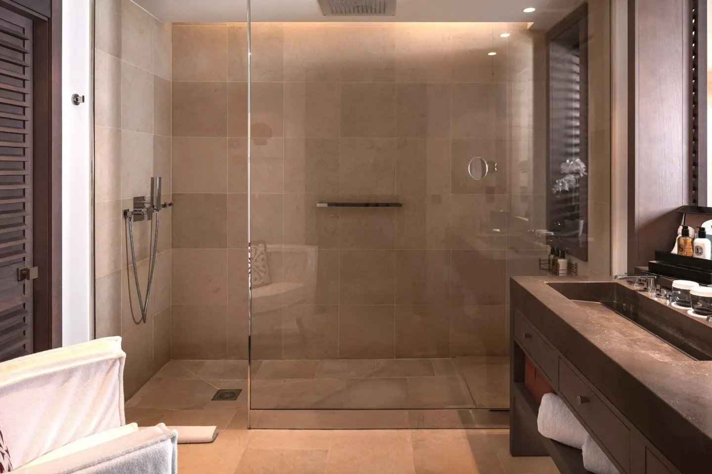 Guest bathroom with large glass shower and vanity at Le Barthélemy Hotel & Spa.