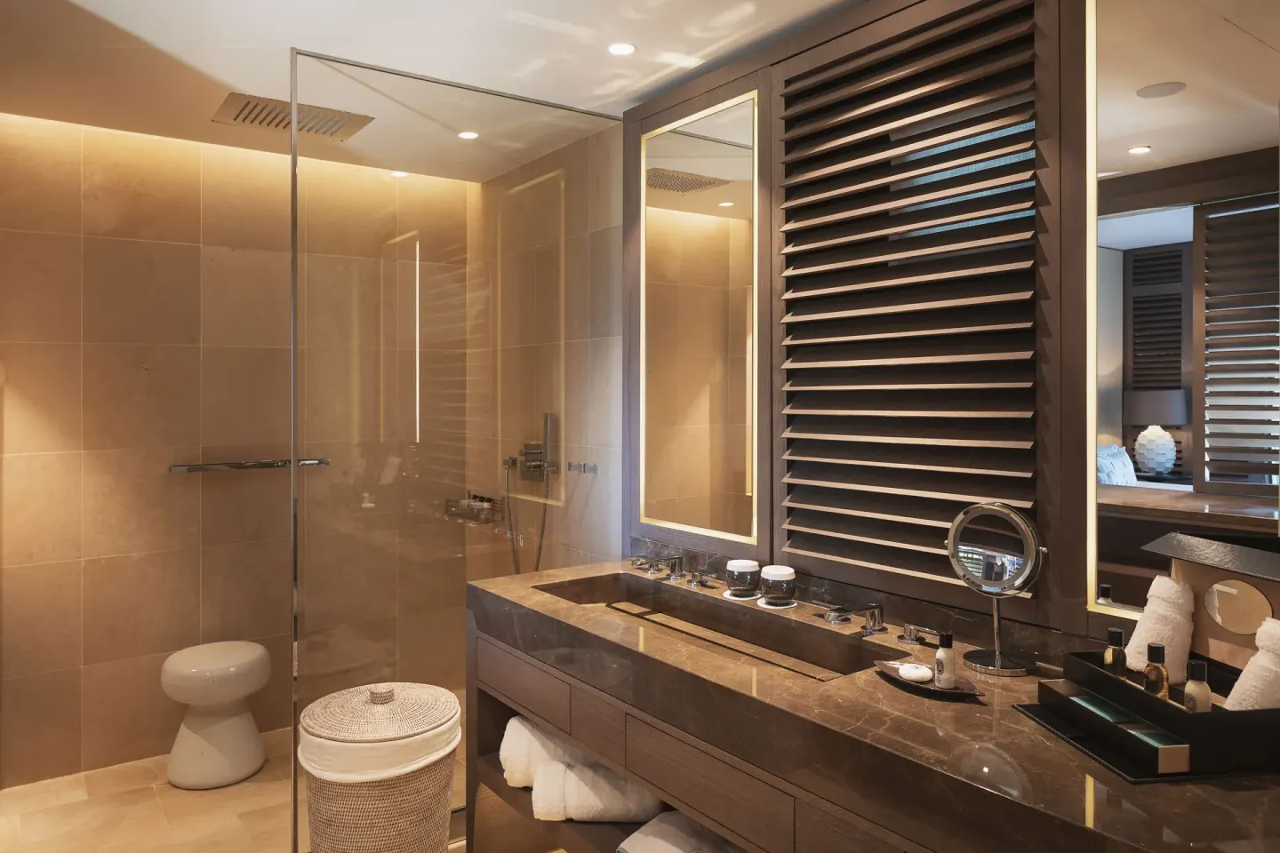 Guest bathroom with marble vanity and glass shower at Le Barthélemy Hotel & Spa.