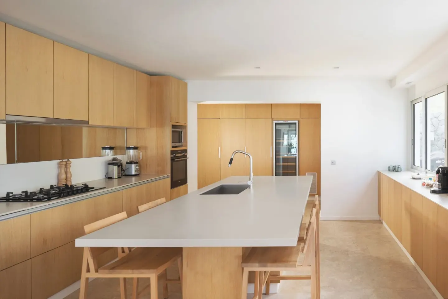 Modern kitchen with island seating and wood cabinetry at Le Barthélemy Hotel & Spa.
