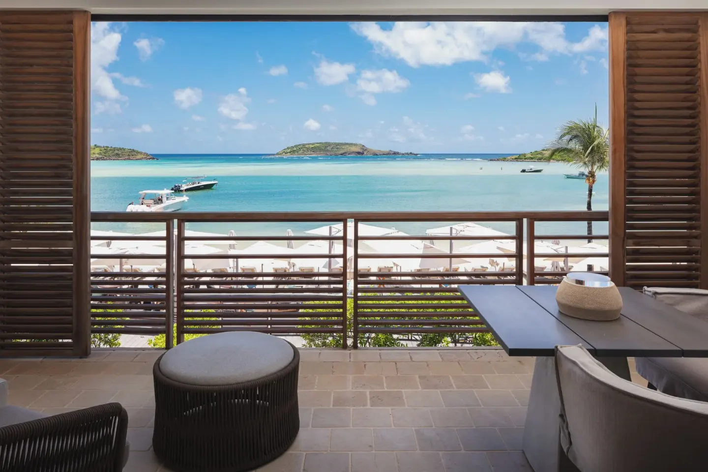 Junior Suite Océan balcony with table, seating, and bay view at Le Barthélemy Hotel & Spa.