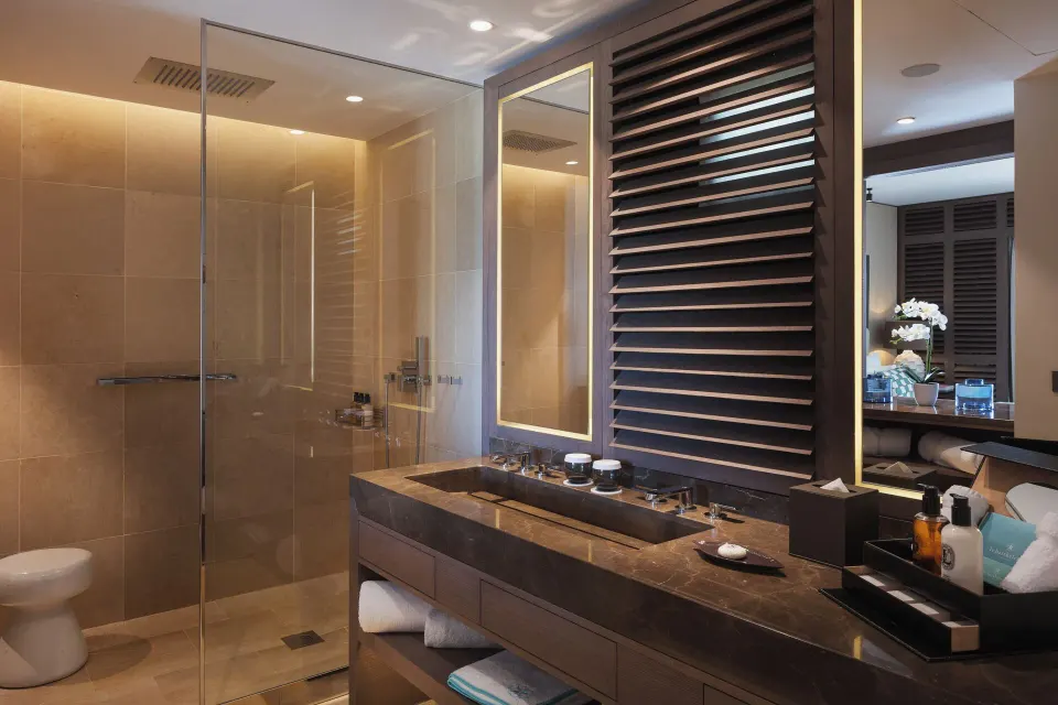 La Suite Signature Plage bathroom with vanity and glass shower at Le Barthélemy Hotel & Spa.