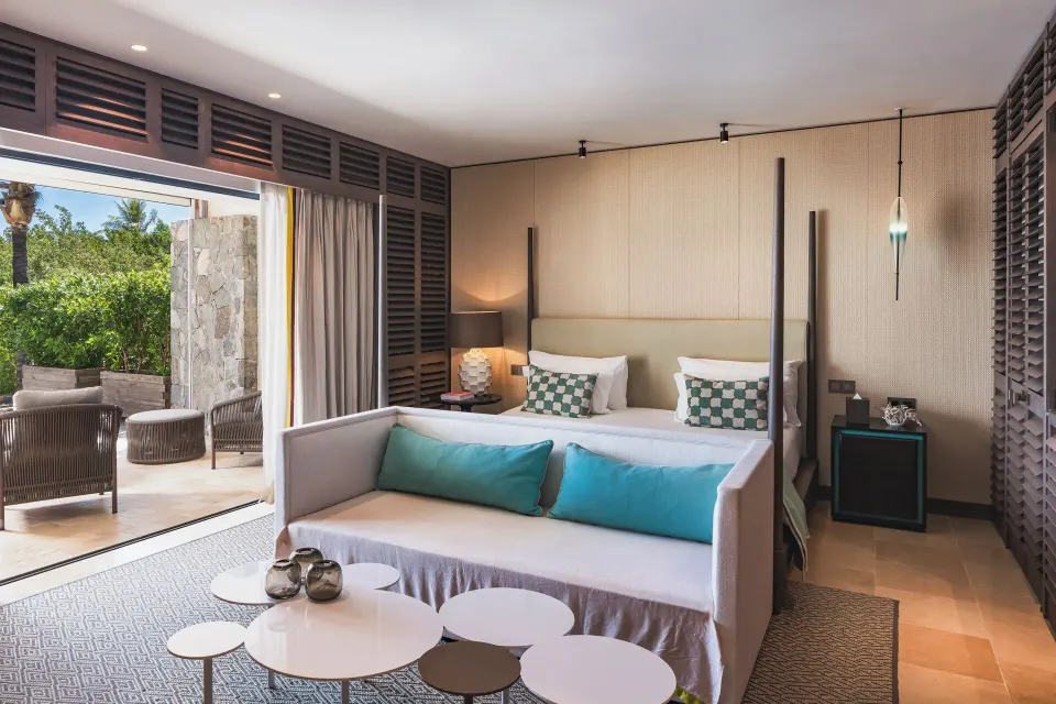 La Suite Signature Plage bedroom with sofa and terrace at Le Barthélemy Hotel & Spa.