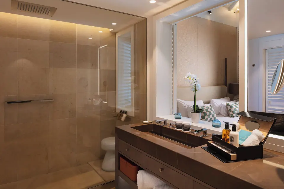 Bathroom vanity and glass shower in Le Barth Océan Vue Mer at Le Barthélemy Hotel & Spa.