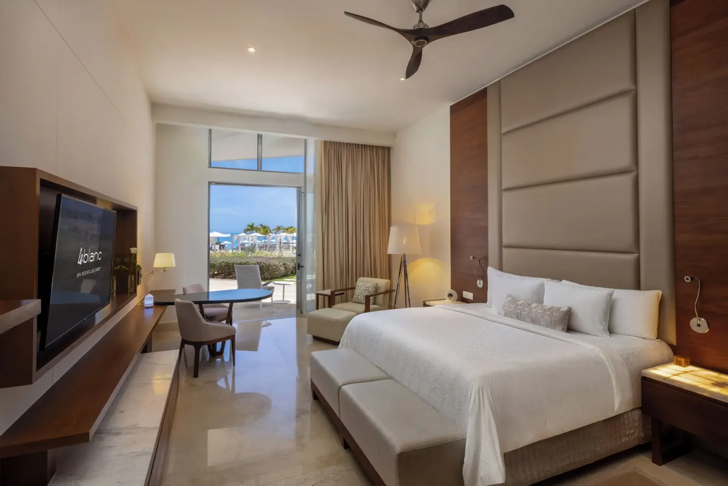Royale Walk Out Suite bedroom with king bed and patio doors at Le Blanc Spa Resort Los Cabos.