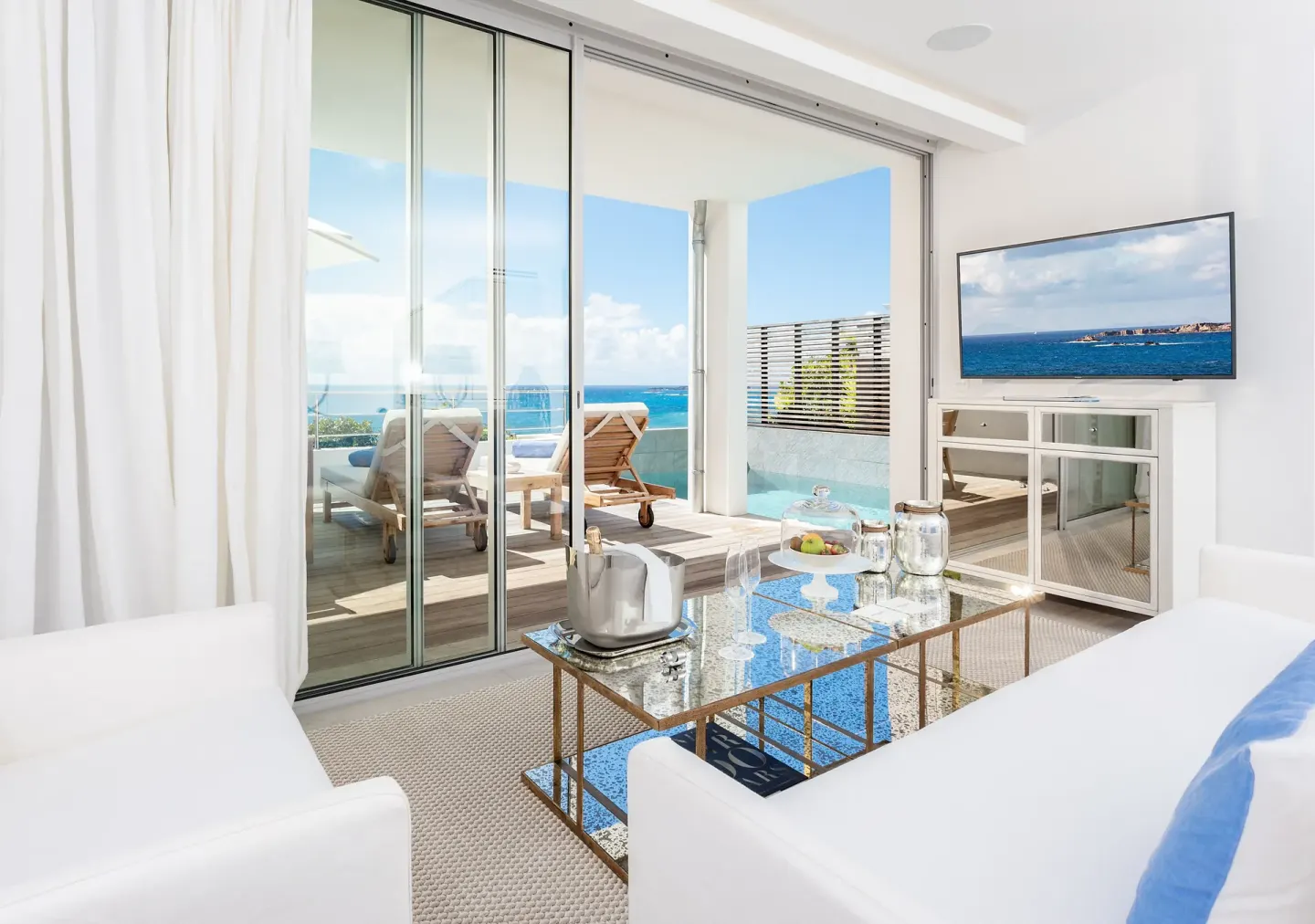 Bright villa lounge with terrace loungers, plunge pool, and sea view at Le Toiny Hôtel & Beach Club.