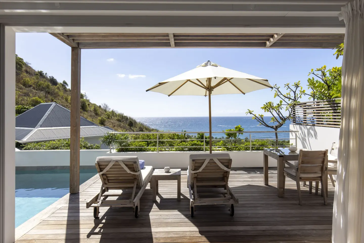 Covered terrace with plunge pool, umbrella and ocean view at Le Toiny Hôtel & Beach Club.