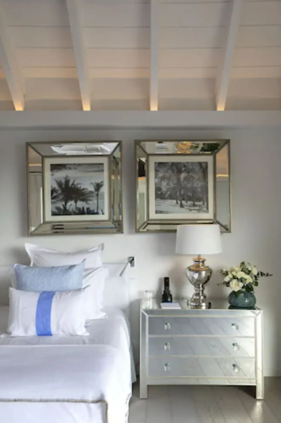 Bedside dresser, lamp, and framed artwork in a guest room at Le Toiny Hôtel & Beach Club.