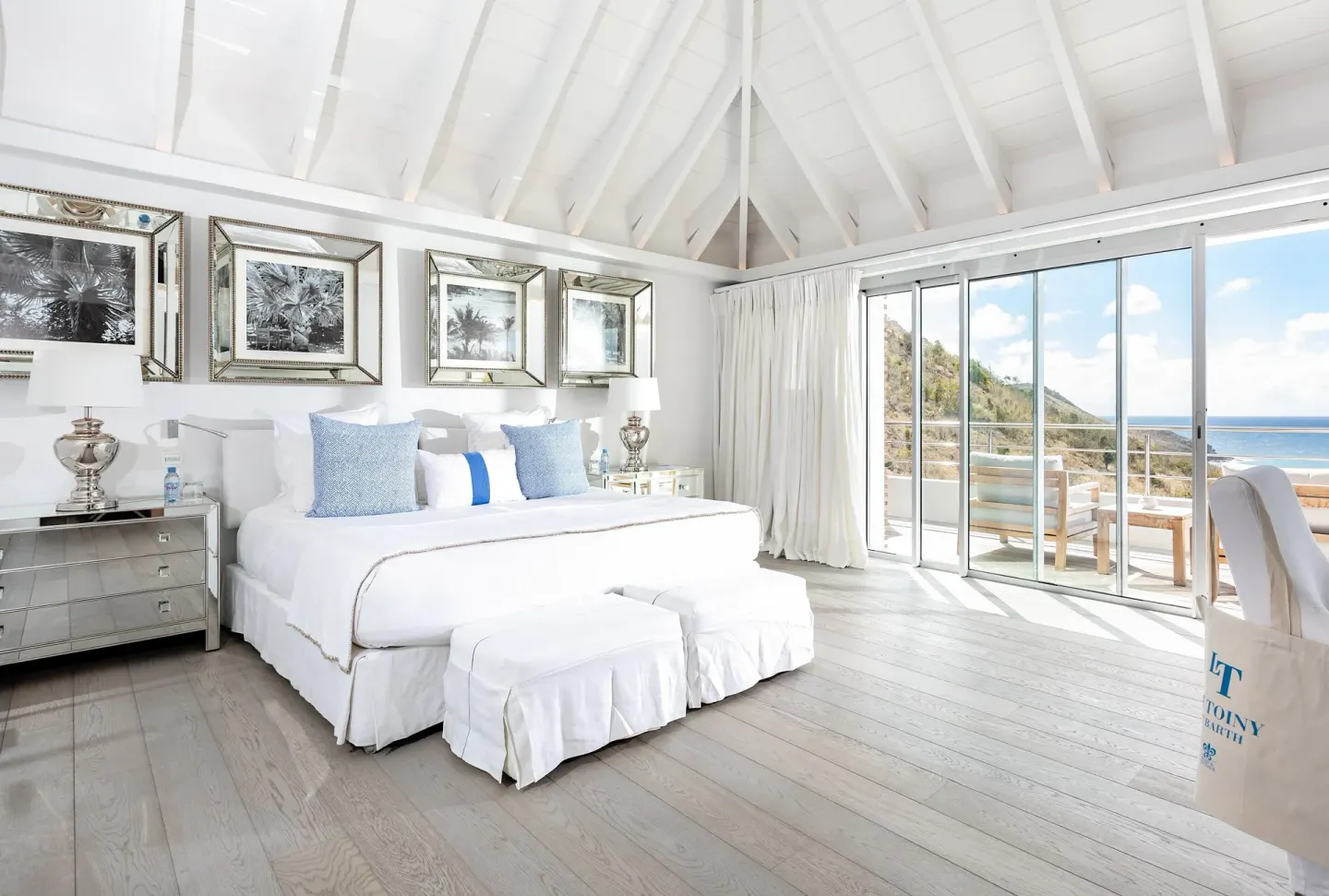 White king bed and ocean-facing terrace in a guest room at Le Toiny Hôtel & Beach Club.