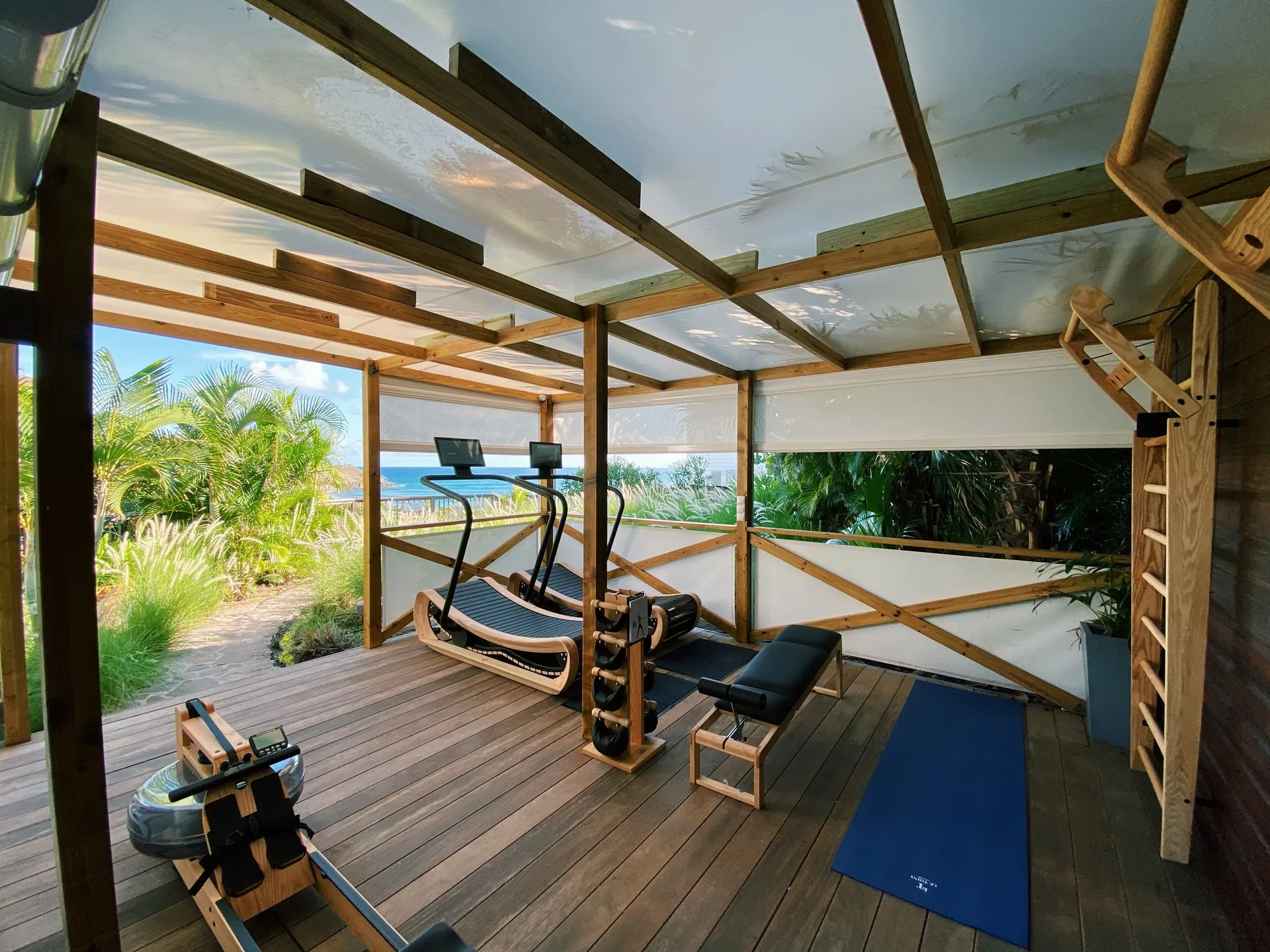 Open-air fitness deck with cardio equipment and weights at Le Toiny Hôtel & Beach Club.