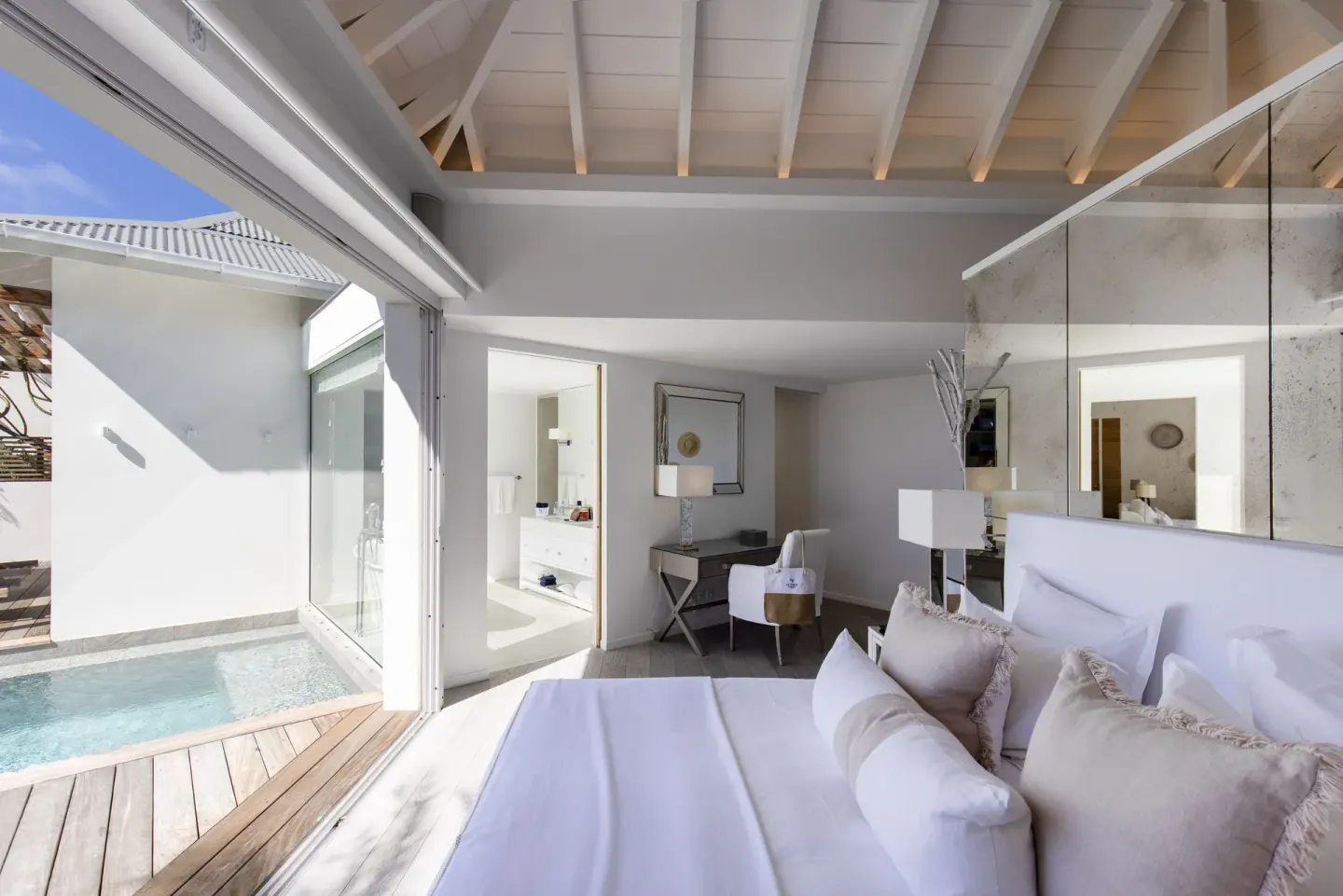 King bed beside sliding doors to a private pool at Le Toiny Hôtel & Beach Club.