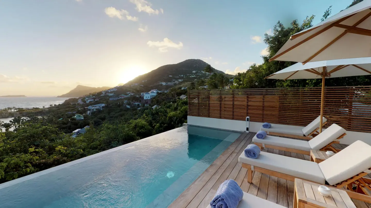 Private pool terrace with loungers at sunset at Le Toiny Hôtel & Beach Club.