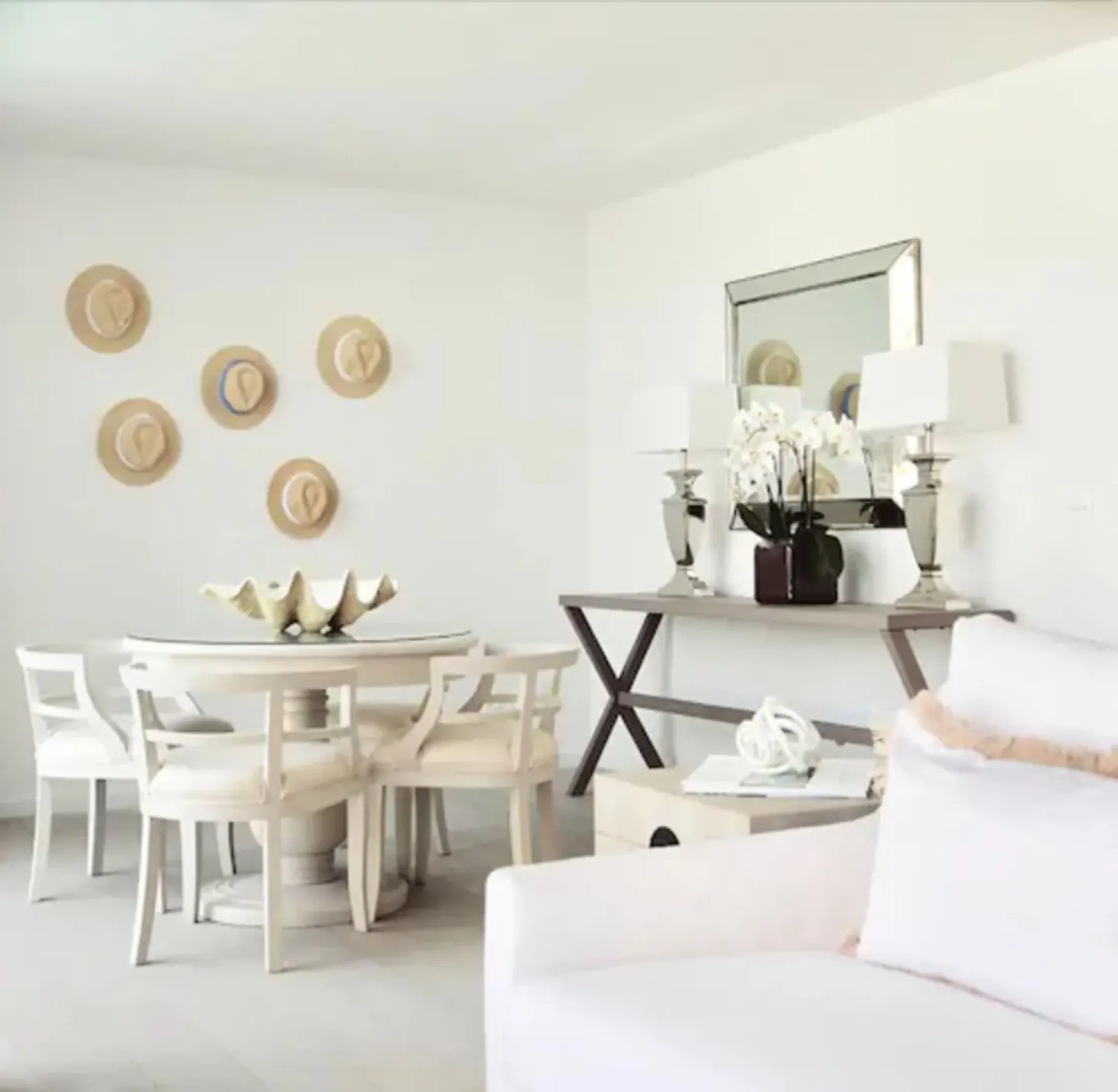White suite dining nook with hat wall and console table at Le Toiny Hôtel & Beach Club.