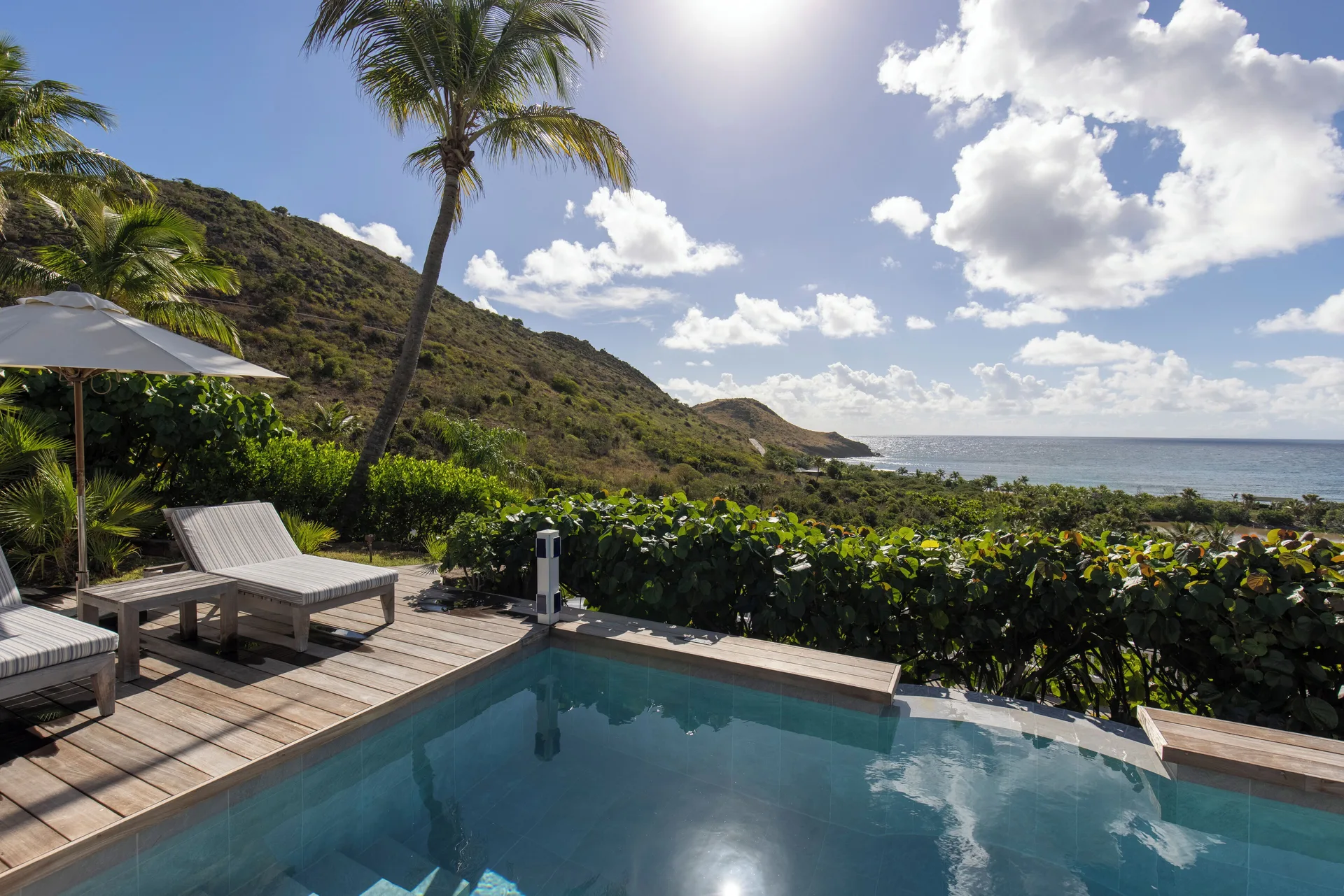 Sunlit private pool and terrace overlooking hills and sea at Le Toiny Hôtel & Beach Club.