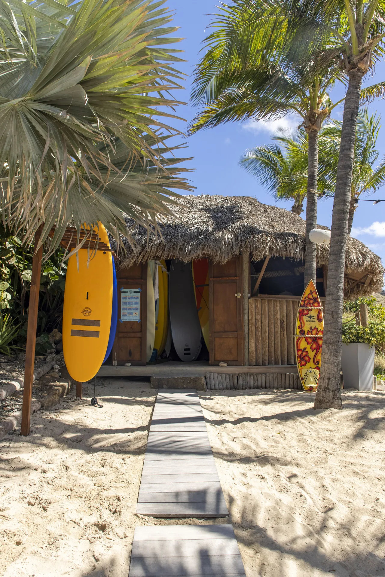 Thatched beach hut with surfboards in the sand at Le Toiny Hôtel & Beach Club.