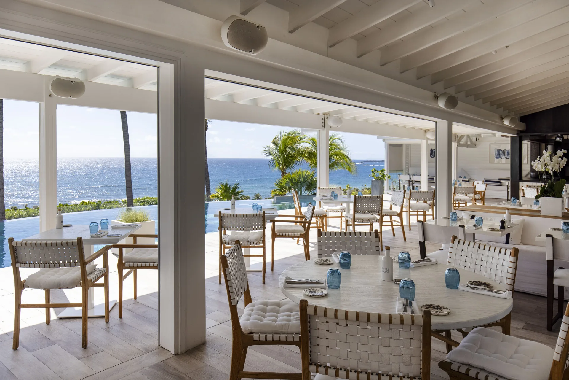 Open-air restaurant seating with ocean views at Le Toiny Hôtel & Beach Club.