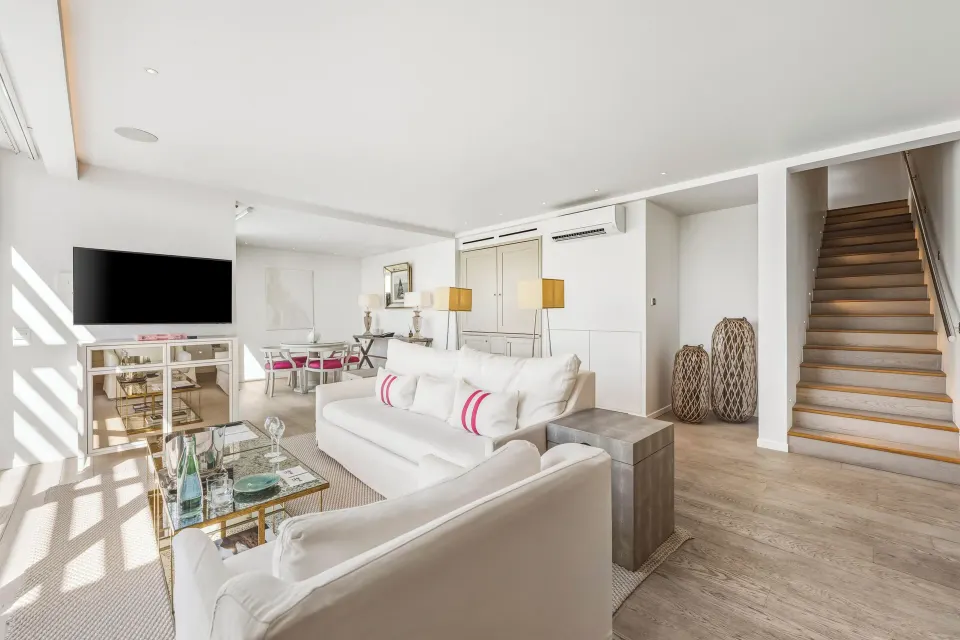 Duplex Spirit Suite living room with sofa and staircase at Le Toiny Hôtel & Beach Club.