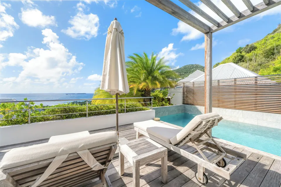 Private pool deck with loungers and ocean view at Le Toiny Hôtel & Beach Club.