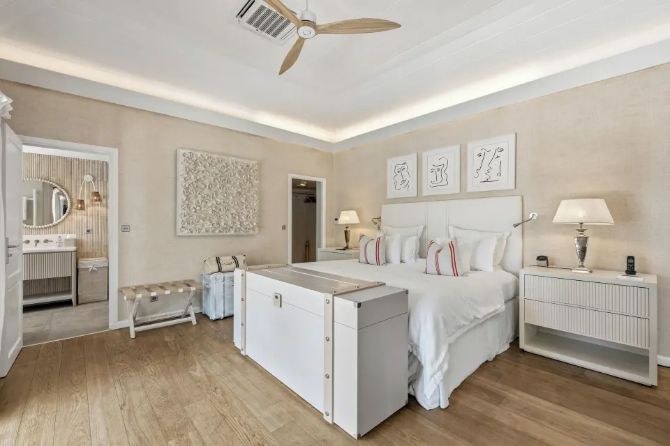 Junior Suite king bed with bathroom doorway at Le Toiny Hôtel & Beach Club.