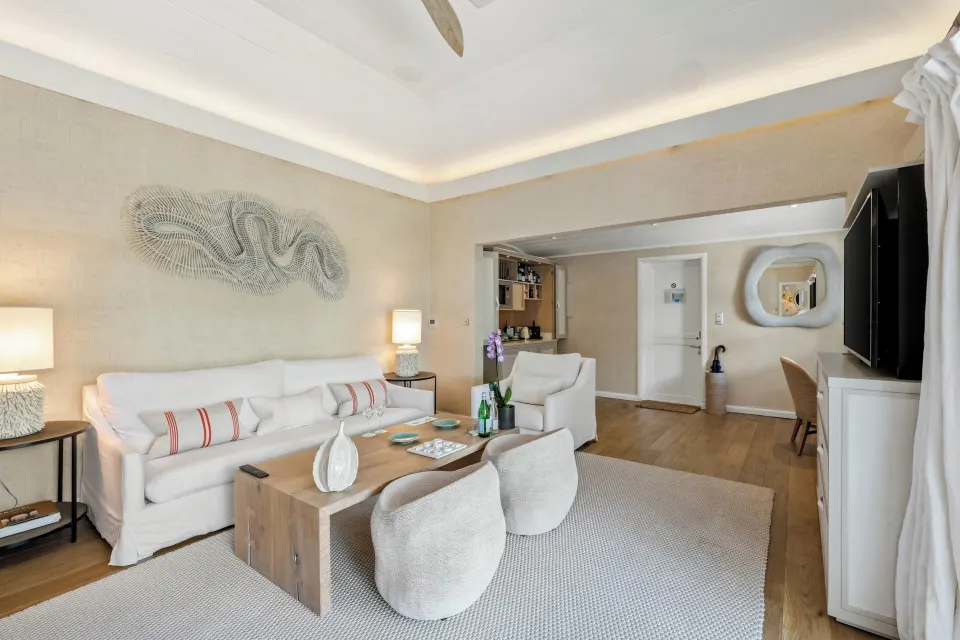 Junior Suite living room with white sofa and coffee table at Le Toiny Hôtel & Beach Club.
