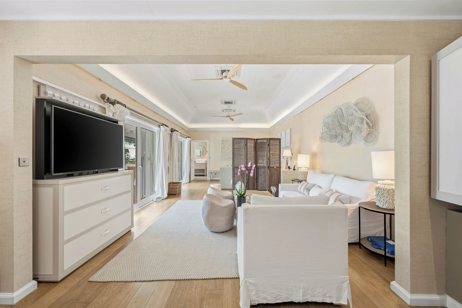 Junior Suite lounge with TV, sofa, and bedroom area beyond at Le Toiny Hôtel & Beach Club.