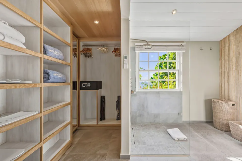 Bathroom and closet area in a Signature Family Suite at Le Toiny Hôtel & Beach Club with glass shower.