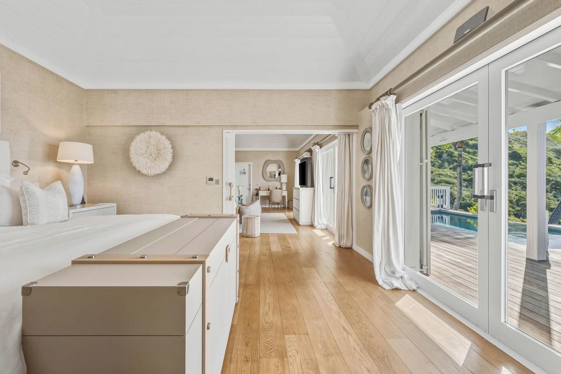 Bedroom in a Signature Family Suite at Le Toiny Hôtel & Beach Club with terrace doors and pool outside.