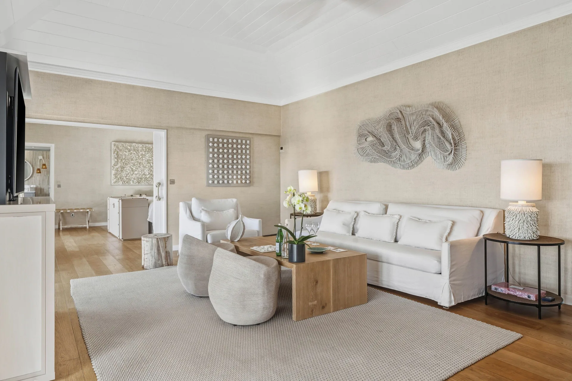 Seating area in a Signature Family Suite at Le Toiny Hôtel & Beach Club with sofa, lamps, and wall art.