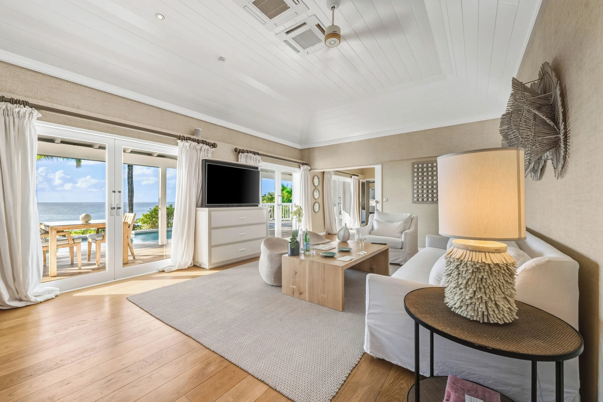 Signature Suite ocean view living room with terrace doors at Le Toiny Hôtel & Beach Club.