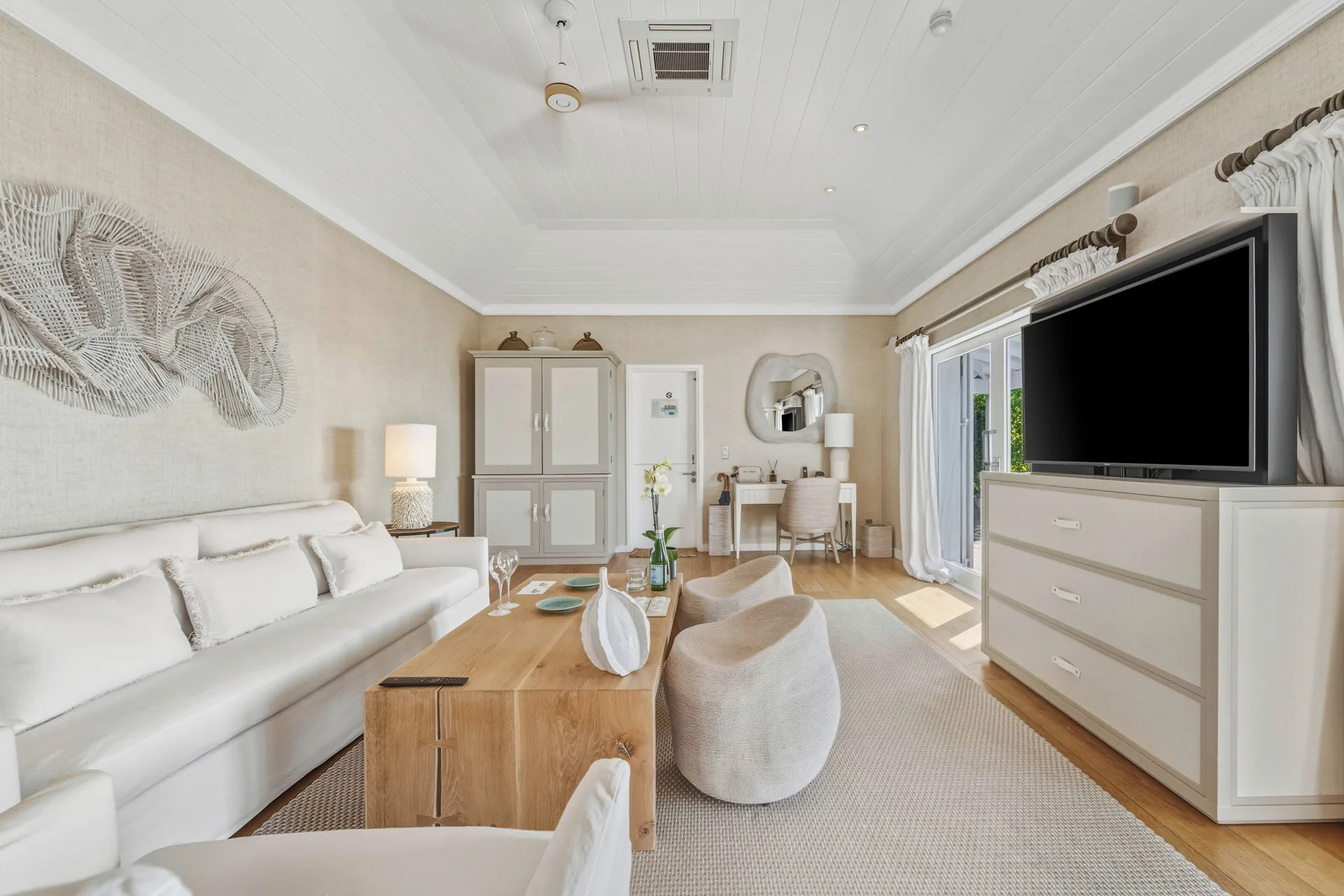 Signature Suite ocean view sitting area with sofa and TV at Le Toiny Hôtel & Beach Club.