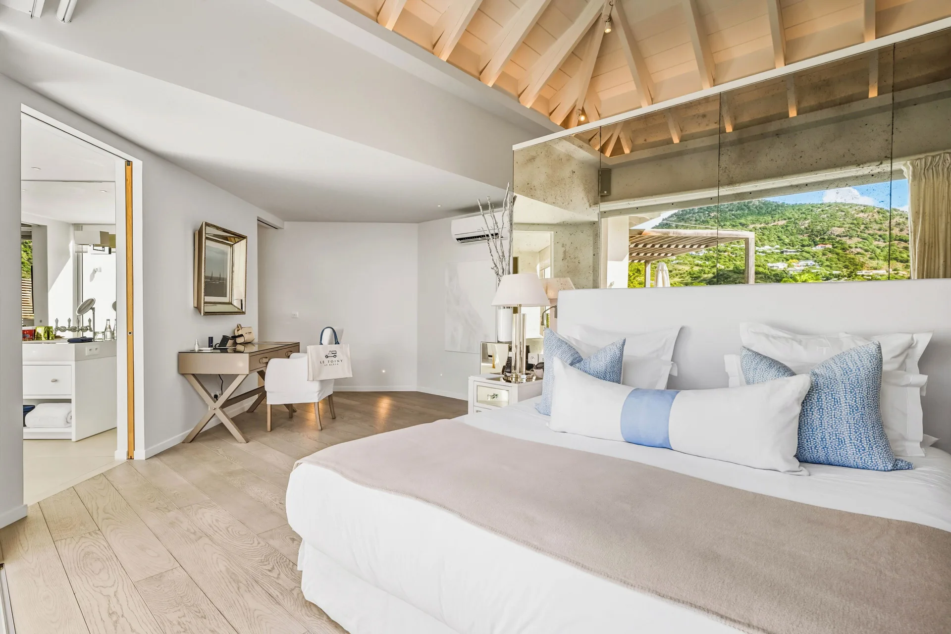 Spirit Suite king bed with desk area and hillside view at Le Toiny Hôtel & Beach Club.