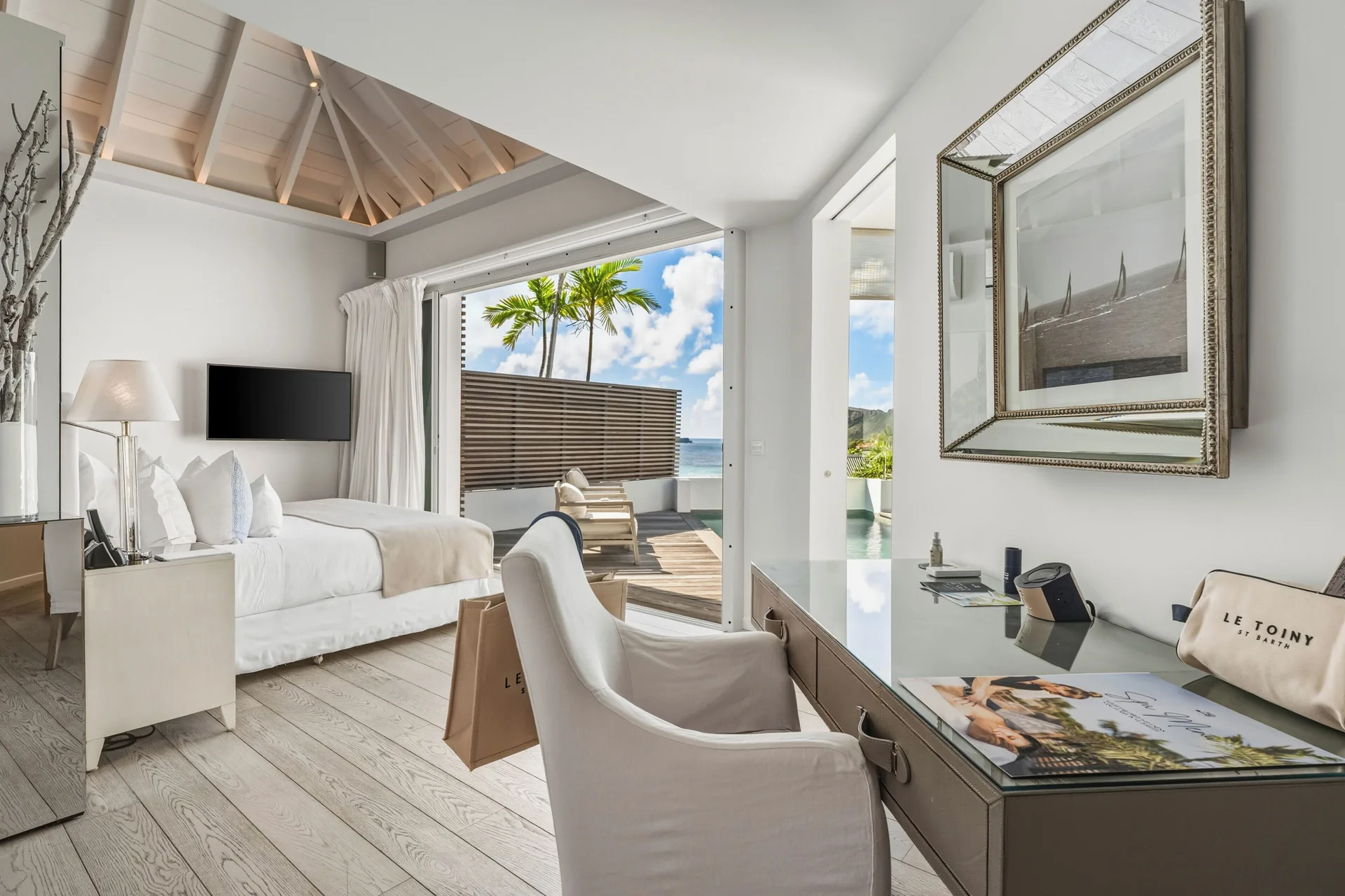Spirit Suite bedroom and writing desk beside the pool terrace at Le Toiny Hôtel & Beach Club.