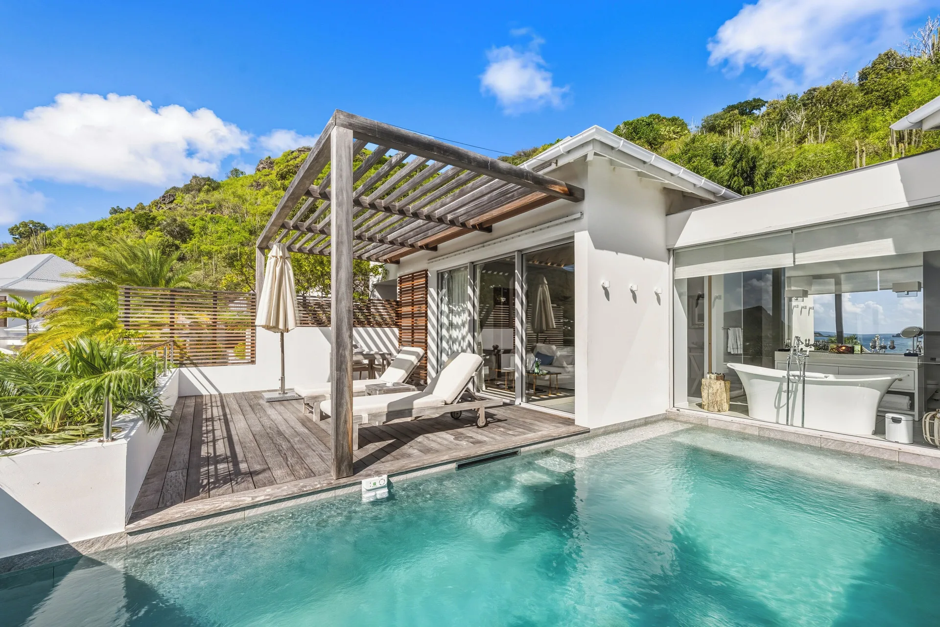 Spirit Suite private pool terrace with loungers and bathroom view at Le Toiny Hôtel & Beach Club.