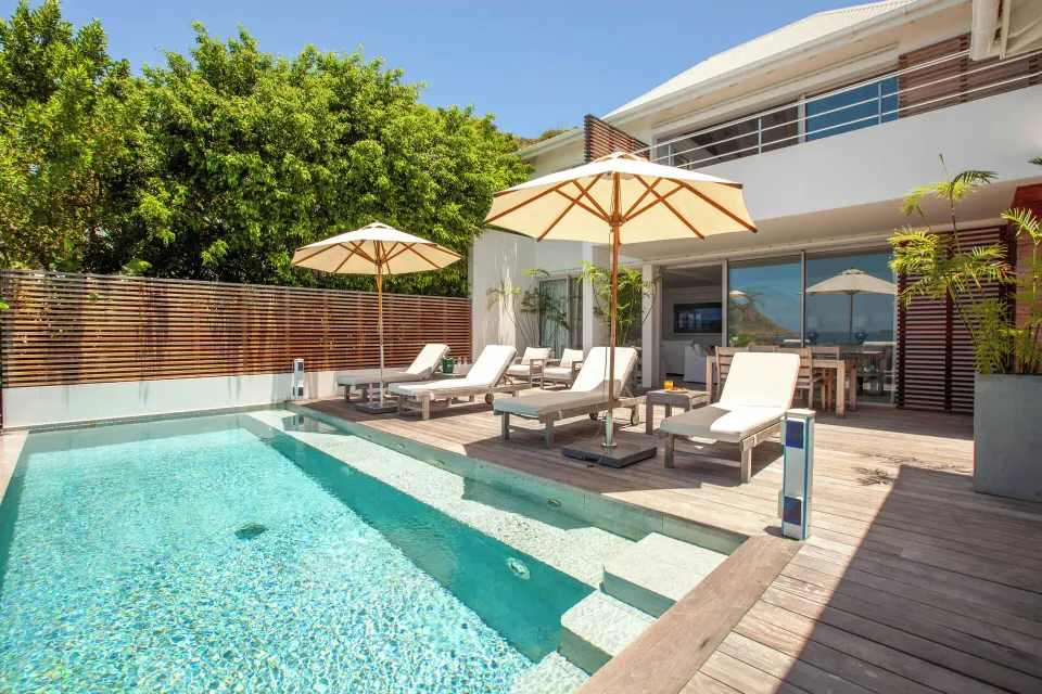 Private pool terrace of a two-bedroom villa at Le Toiny Hôtel & Beach Club with loungers and umbrellas.