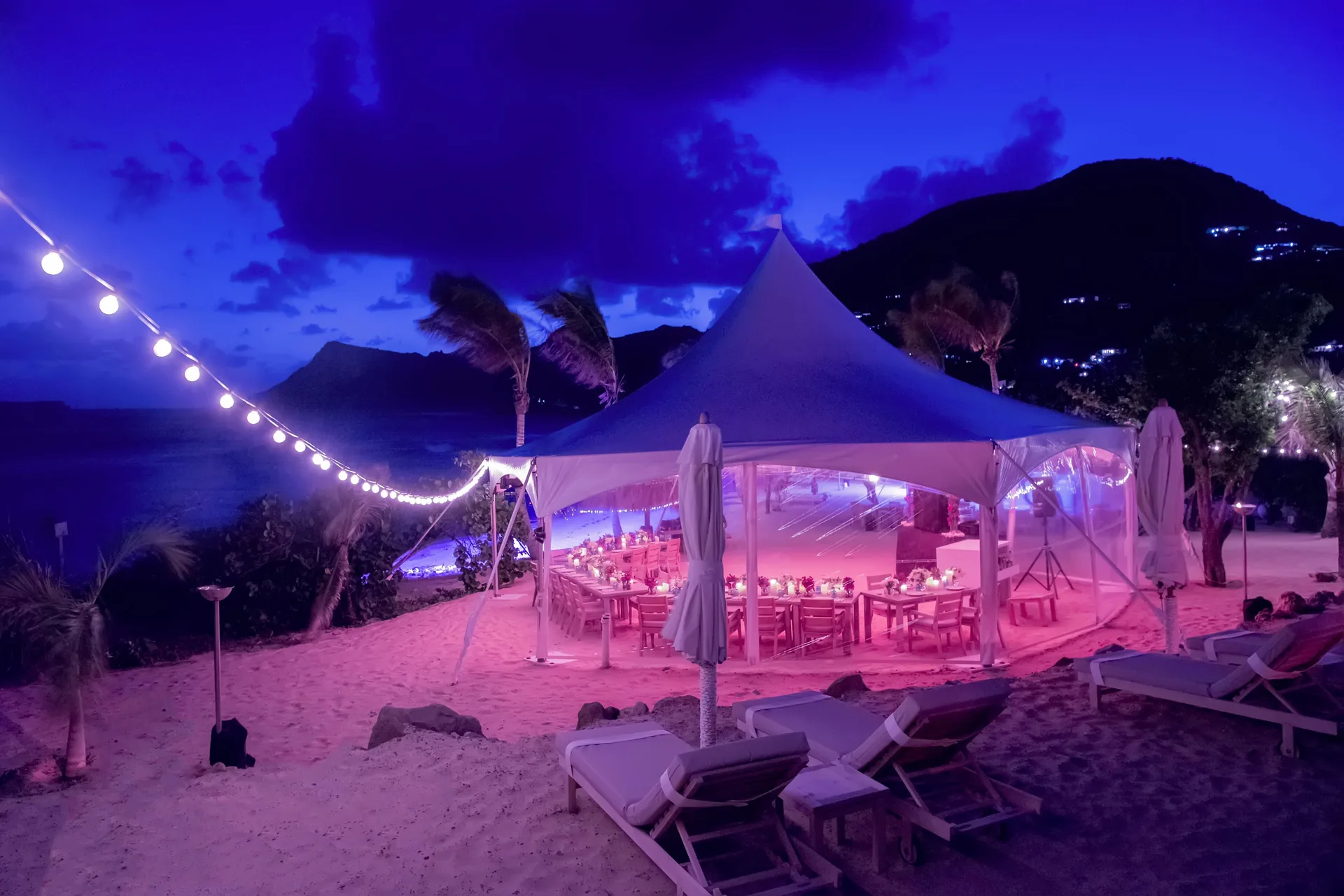 Beachfront event tent lit at dusk at Le Toiny Hôtel & Beach Club.