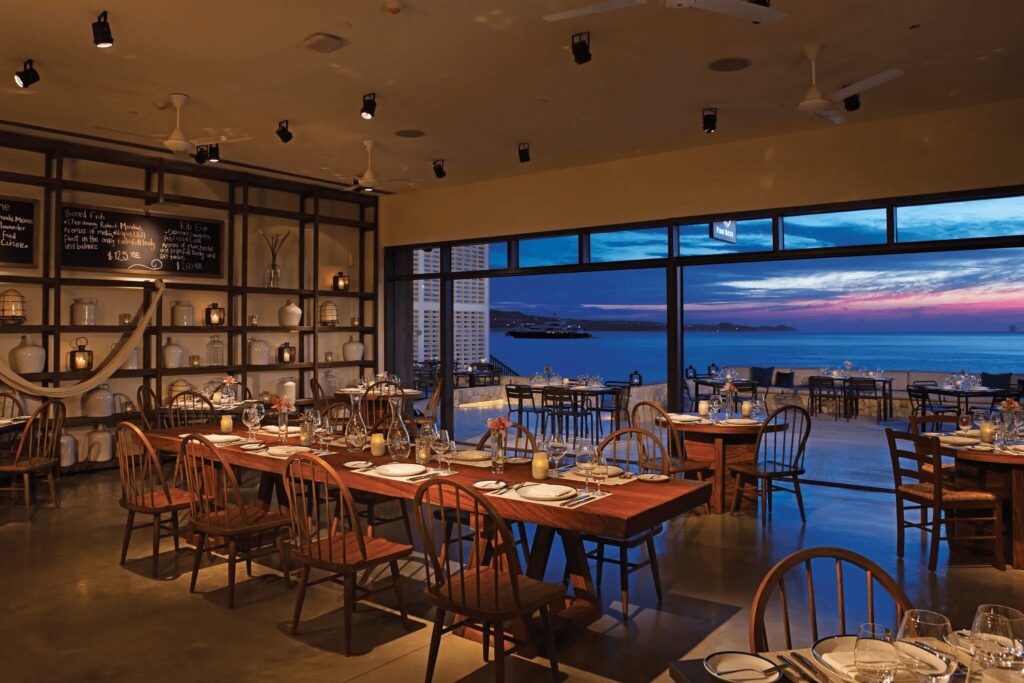 Outdoor sunset dining at Breathless Cabo San Lucas with guests enjoying gourmet cuisine and oceanfront views.
