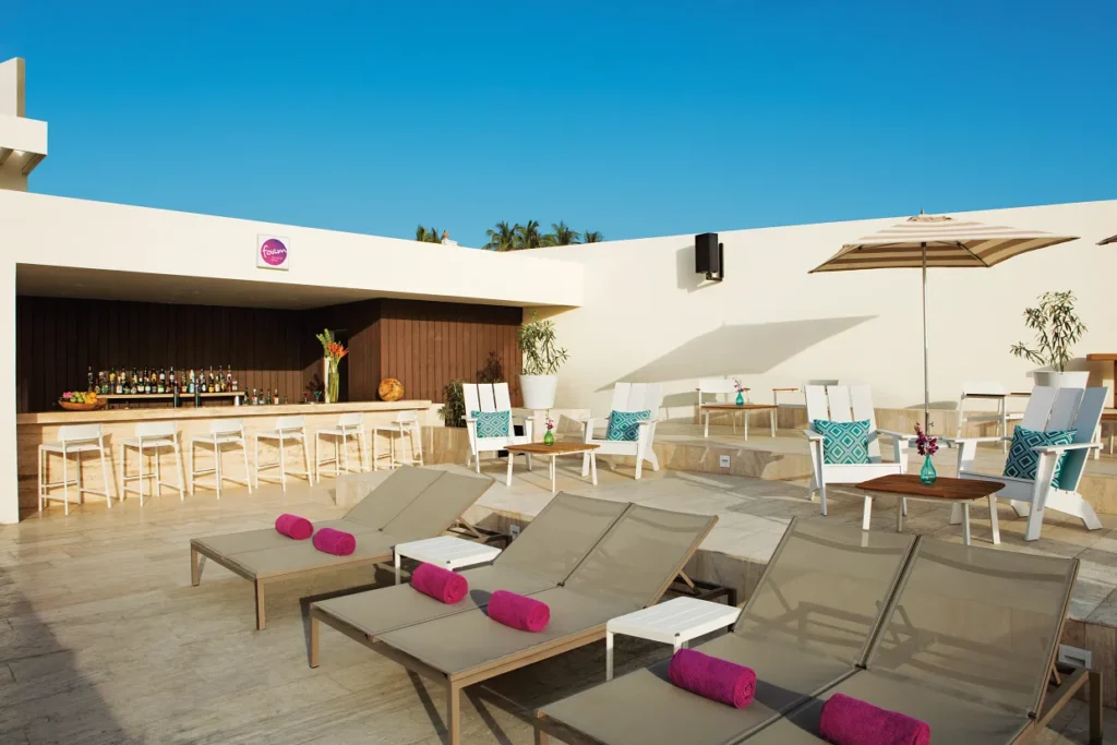 Foam Bar poolside terrace with lounge chairs and cocktails at Breathless Cabo San Lucas.