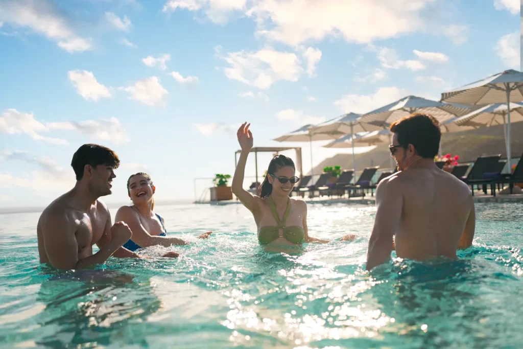 Group of friends enjoying the infinity pool with ocean views at Breathless Cabo San Lucas