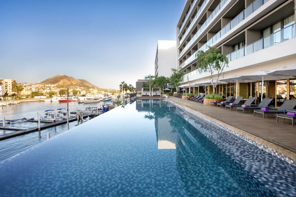 Marinafront infinity pool at Breathless Cabo San Lucas with loungers and umbrellas