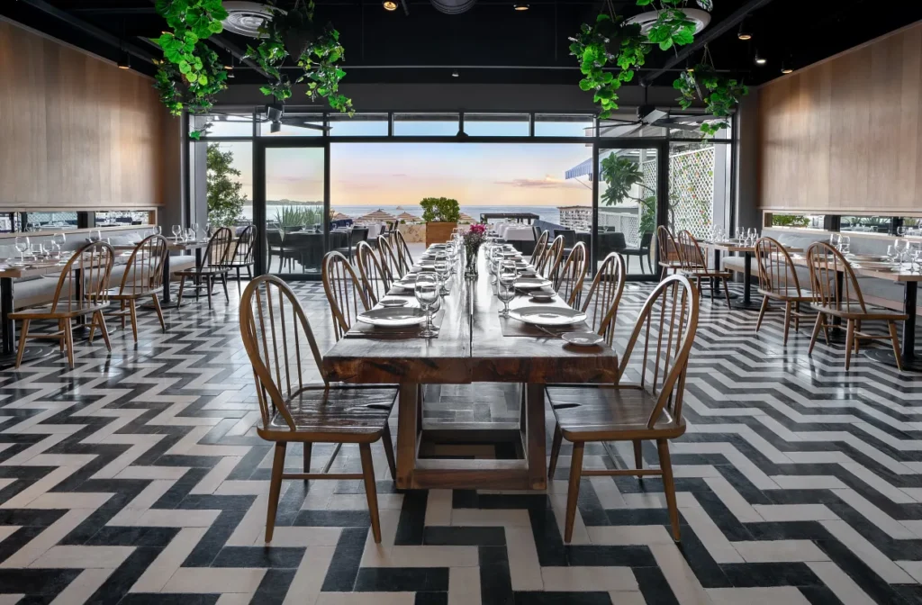 Elegant dining at Spumante restaurant with long wooden tables and wine-focused ambience at Breathless Cabo San Lucas.
