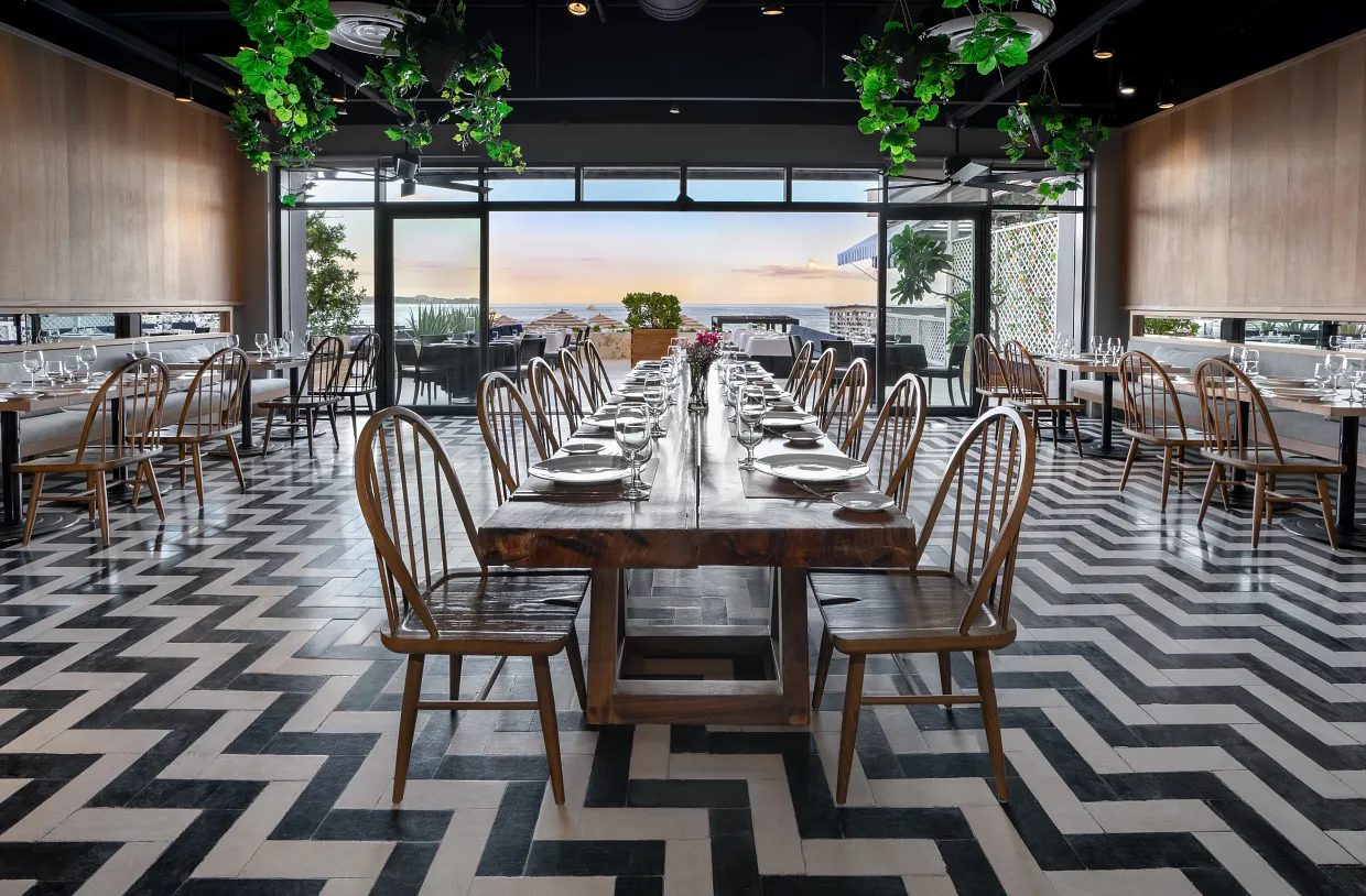 Elegant dining at Spumante restaurant with long wooden tables and wine-focused ambience at Breathless Cabo San Lucas.