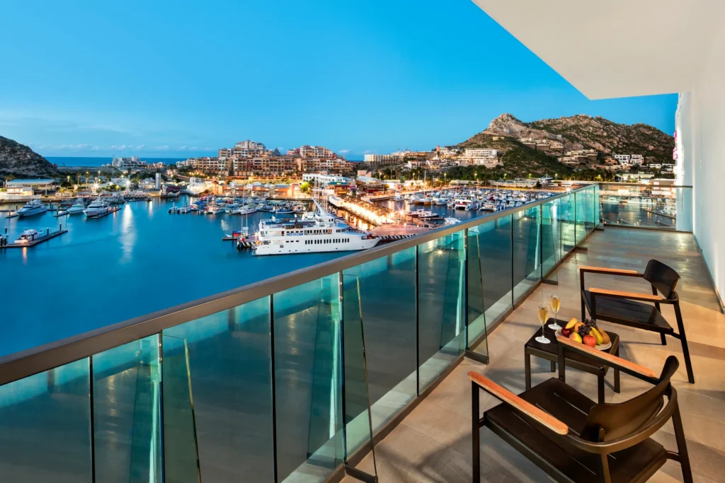 Private balcony with evening marina views from the Xhale Club Master One Bedroom Suite at Breathless Cabo San Lucas.