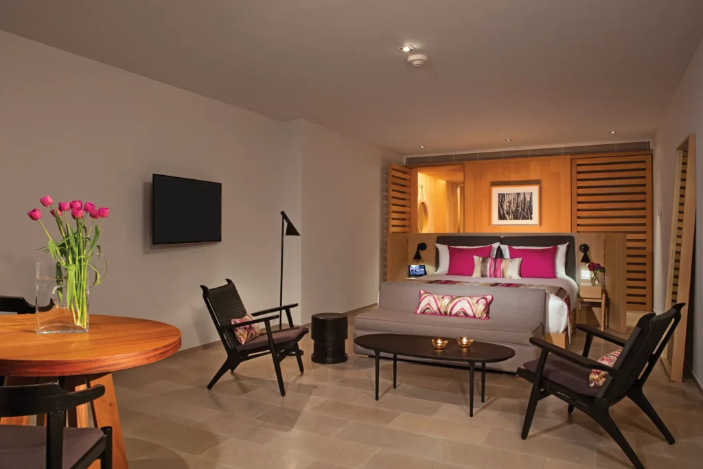 Luxurious king-bed Xhale Club Suite Marina View at Breathless Cabo San Lucas with modern seating area.