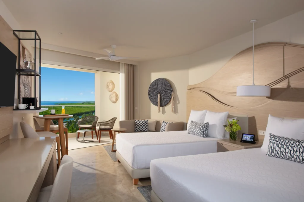 Allure Junior Suite Lagoon View with two double beds and balcony at Breathless Cancun Soul Resort overlooking the lagoon.