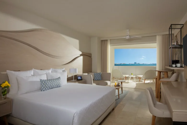 Allure Junior Suite Live Big Lagoon View with king bed at Breathless Cancun Soul Resort overlooking the lagoon.