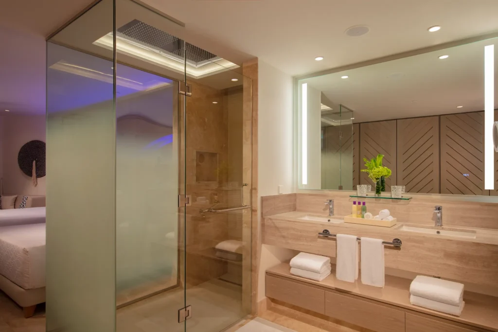 Modern bathroom in the Allure Junior Suite Ocean View at Breathless Cancun Soul Resort with glass shower and double vanity.
