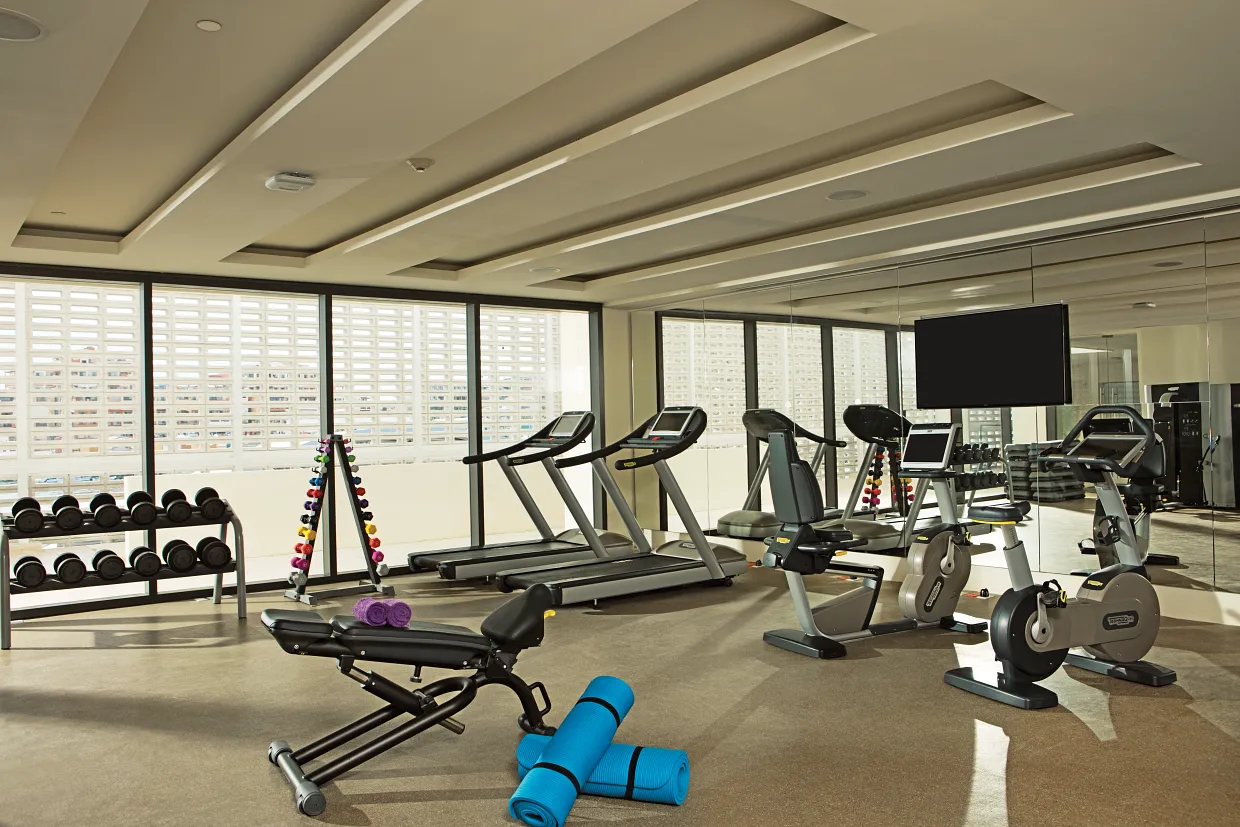 Modern fitness center at Breathless Cabo San Lucas with treadmills, weights, and cardio equipment.